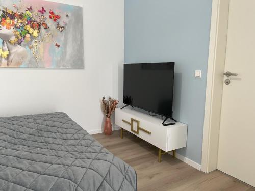 a bedroom with a bed and a flat screen tv at STAYWELL I Südstadt Für 4 I CO2 Free in Paderborn