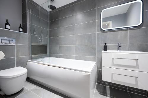 Baño blanco con aseo y lavamanos en Luxury Apartment by Ocean Village Marina en Southampton