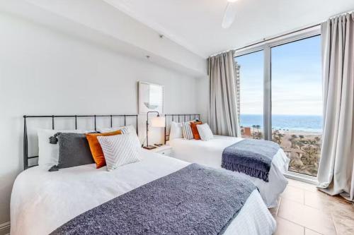 two beds in a room with a view of the ocean at Portofino Island P2-905 in Pensacola Beach