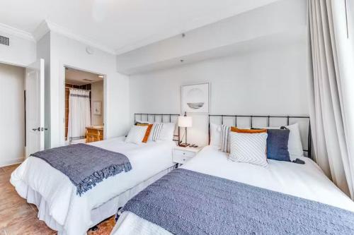 two beds in a bedroom with white walls at Portofino Island P2-905 in Pensacola Beach