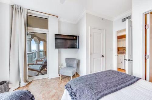 a bedroom with a bed and a chair and a mirror at Portofino Island P2-905 in Pensacola Beach