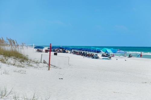a beach with a group of people and the ocean at Portofino Island P2-905 in Pensacola Beach