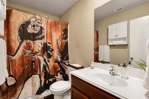 y baño con aseo y cortina de ducha. en Speakeasy - A Birdy Vacation Rental en San Antonio