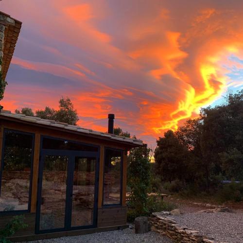 a building with a sunset in the background at Mas de l'Arlequi in Rojals