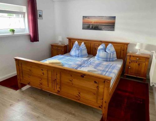 a bedroom with a wooden bed with blue pillows on it at Ferienwohnung Flunder in Zempin