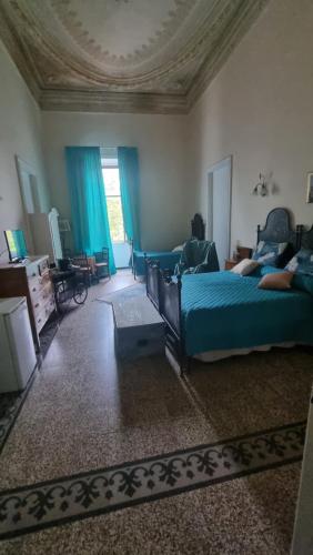 a bedroom with two beds and blue curtains at B& B Cà de Andreas in Catania
