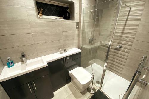 a bathroom with a shower and a toilet and a sink at Boss Breaks-Luton in Luton