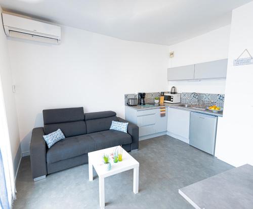 un salon avec un canapé et une table dans l'établissement LE PACIFICA APPART - Neuf Parking WIFI CLIM 2min PLAGE - Résidence Le Pacific - TopProsConciergerie La Grande Motte, à La Grande Motte