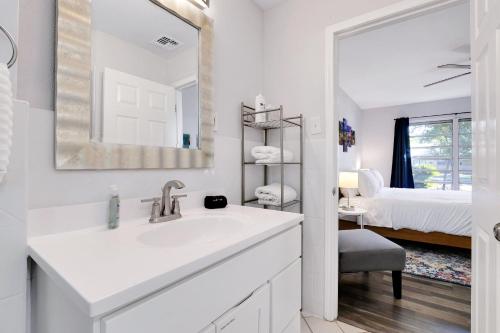 a white bathroom with a sink and a bedroom at Texas Star - A Birdy Vacation Rental in San Antonio