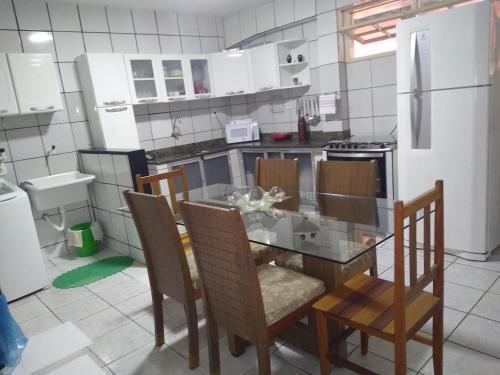 a kitchen with a table and chairs and a refrigerator at Apartamento in Porto Seguro