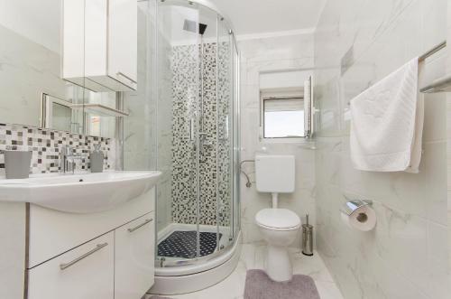 y baño con ducha, aseo y lavamanos. en Apartments A-Z, en Stara Novalja