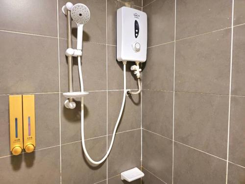eine Dusche im Bad mit einem Haartrockner an der Wand in der Unterkunft Tiara Imperio Studio 酒店风格与阳台泳池美景 in Bangi