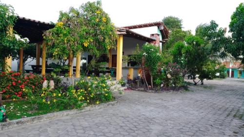 un jardin avec des fleurs en face d'une maison dans l'établissement Pousada Luz - Santo Amaro do Maranhão, à Santo Amaro