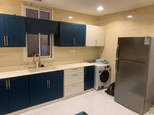 La cuisine est équipée d'un réfrigérateur et d'un lave-linge. dans l'établissement شقه انيقه وموقع مميز, à Dammam