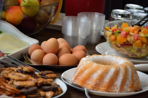 een tafel vol met schalen eieren en een fruitschaal bij Hotel Luxor Florence in Florence