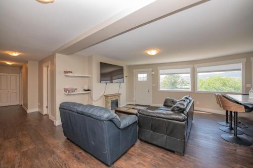 a living room with two leather couches and a fireplace at Lakeviews, big yard/deck, minutes to Silver Star/Golf/Wineries. in Vernon