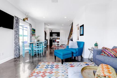 a living room with blue chairs and a dining room at Urban - A Birdy Vacation Rental in San Antonio