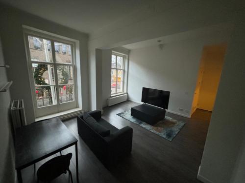 a living room with a couch and a television at Hermanos City Appartement in Enschede