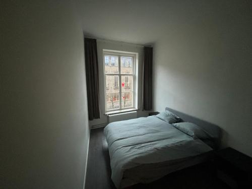 een slaapkamer met een bed en een raam bij Hermanos City Appartement in Enschede