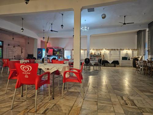 a dining room with red chairs and a table at Archimedes Tourist Sp. z o.o. in Międzyrzecz