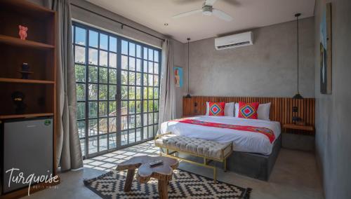 a bedroom with a bed and a large window at Turquoise Tulum Hotel in Tulum