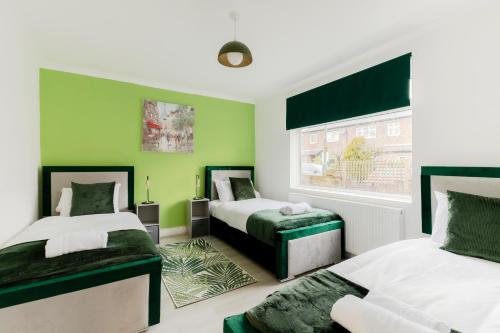 two beds in a room with green walls at 5BR House, Free Parking offA12, Contractor, Big Families, Relocation in Redbridge