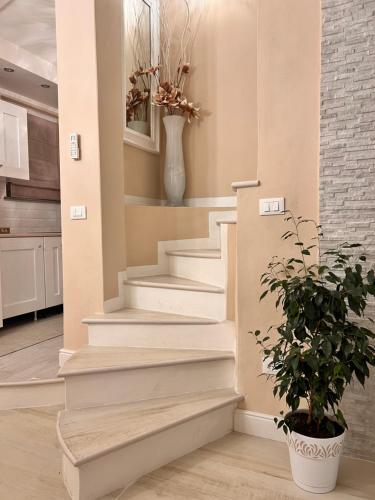 un escalier dans une cuisine avec un vase et une plante dans l'établissement Appartamento LA TORRETTA, à Ponsacco