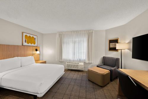 a hotel room with a bed and a chair at Sonesta Simply Suites Jersey City in Jersey City