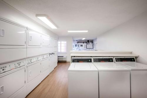 a large white kitchen with white cabinets and appliances at Sonesta Simply Suites Jersey City in Jersey City