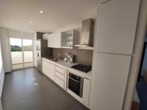 a kitchen with white cabinets and a stove top oven at Yaque Suite in El Yaque