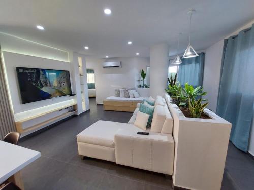 a living room with a white couch and a tv at Yaque Suite in El Yaque
