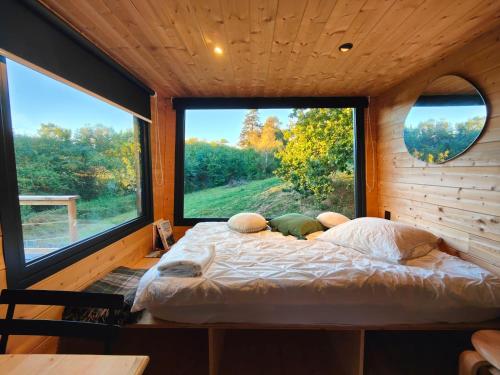 a bed in a room with a large window at Tiny House MOOSE HOME Les Chaumes in Les Ancizes-Comps