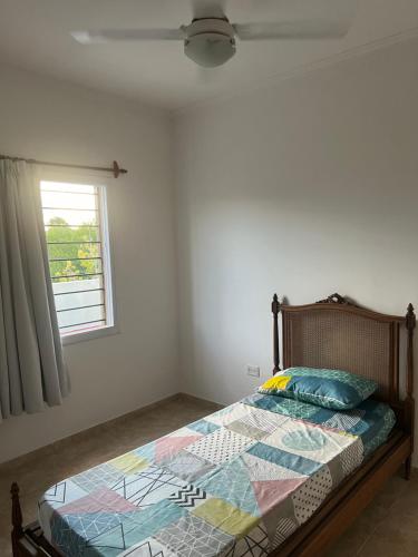 Schlafzimmer mit einem Bett und einem Fenster in der Unterkunft Las Emes in Suipacha