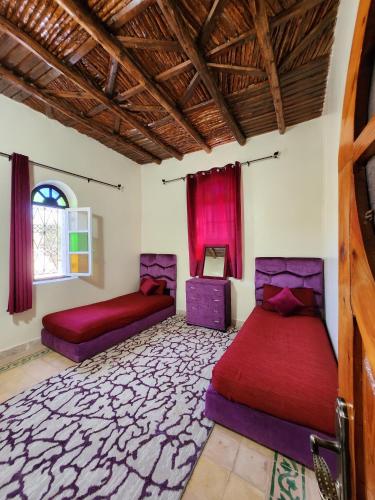 1 dormitorio con 2 camas y ventana en Villa mgm, en Bou Mkila