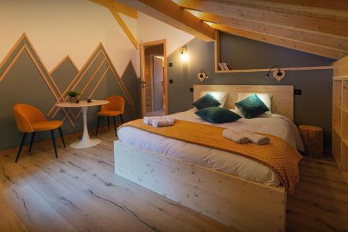 a bedroom with a bed and a table and chairs at Chalet Julero - OVO Network in Le Grand-Bornand