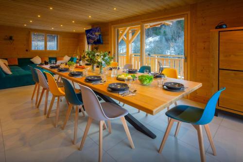 a dining room with a long wooden table and chairs at Chalet Julero - OVO Network in Le Grand-Bornand