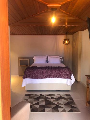 a bedroom with a large bed in a room at Pousada Chalé dos Ipês in Santa Teresa