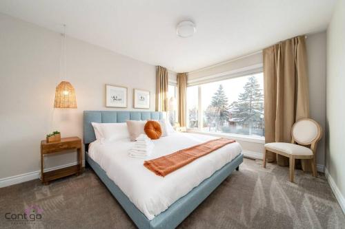 een slaapkamer met een groot bed en een raam bij The Azure, Near DT & University, TWO King Beds! in Edmonton