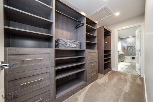 a walk in closet with dark wood cabinets at The Azure, Near DT & University, TWO King Beds! in Edmonton
