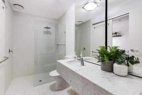 een witte badkamer met een wastafel en een toilet bij Nook Melbourne Apartments : Jane Bell Lane - Melbourne CBD in Melbourne