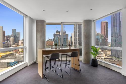 a room with a view of a city skyline at Nook Melbourne Apartments : Jane Bell Lane - Melbourne CBD in Melbourne