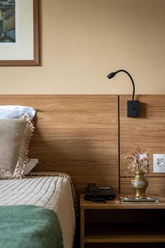 a bedroom with a bed and a lamp on a table at Studios Exclusivos Xavishome Granja Brasil Itaipava in Itaipava