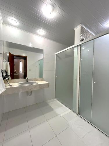 a bathroom with a glass shower and a sink at Regente Hotel in Pato Branco