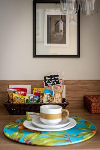 a basket of food and a plate on a table at Studios Exclusivos Xavishome Granja Brasil Itaipava in Itaipava