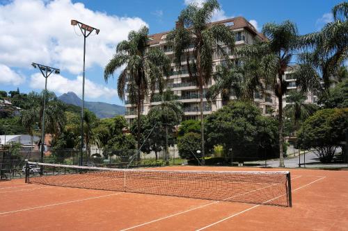 a tennis court in front of a building at Studios Exclusivos Xavishome Granja Brasil Itaipava in Itaipava