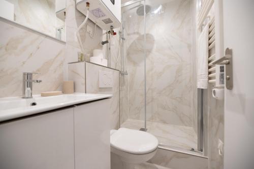 une salle de bain blanche avec toilettes et douche dans l'établissement Cosy apartment in Paris, à Paris