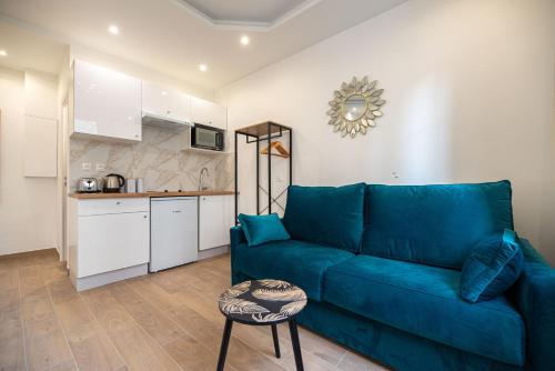 un salon avec un canapé bleu et une cuisine dans l'établissement Cosy apartment in Paris, à Paris