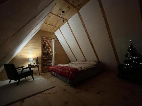 a bedroom with a bed and a christmas tree at Bobbie's Cottage - Bobijeva Vikendica in Antonići