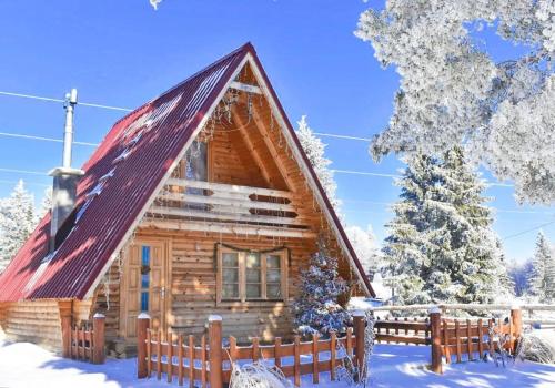 a log cabin in the snow with a fence at Bobbie's Cottage - Bobijeva Vikendica in Antonići