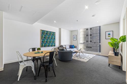 een woonkamer met een tafel en een bank bij Nook Melbourne Apartments : Jane Bell Lane - Melbourne CBD in Melbourne